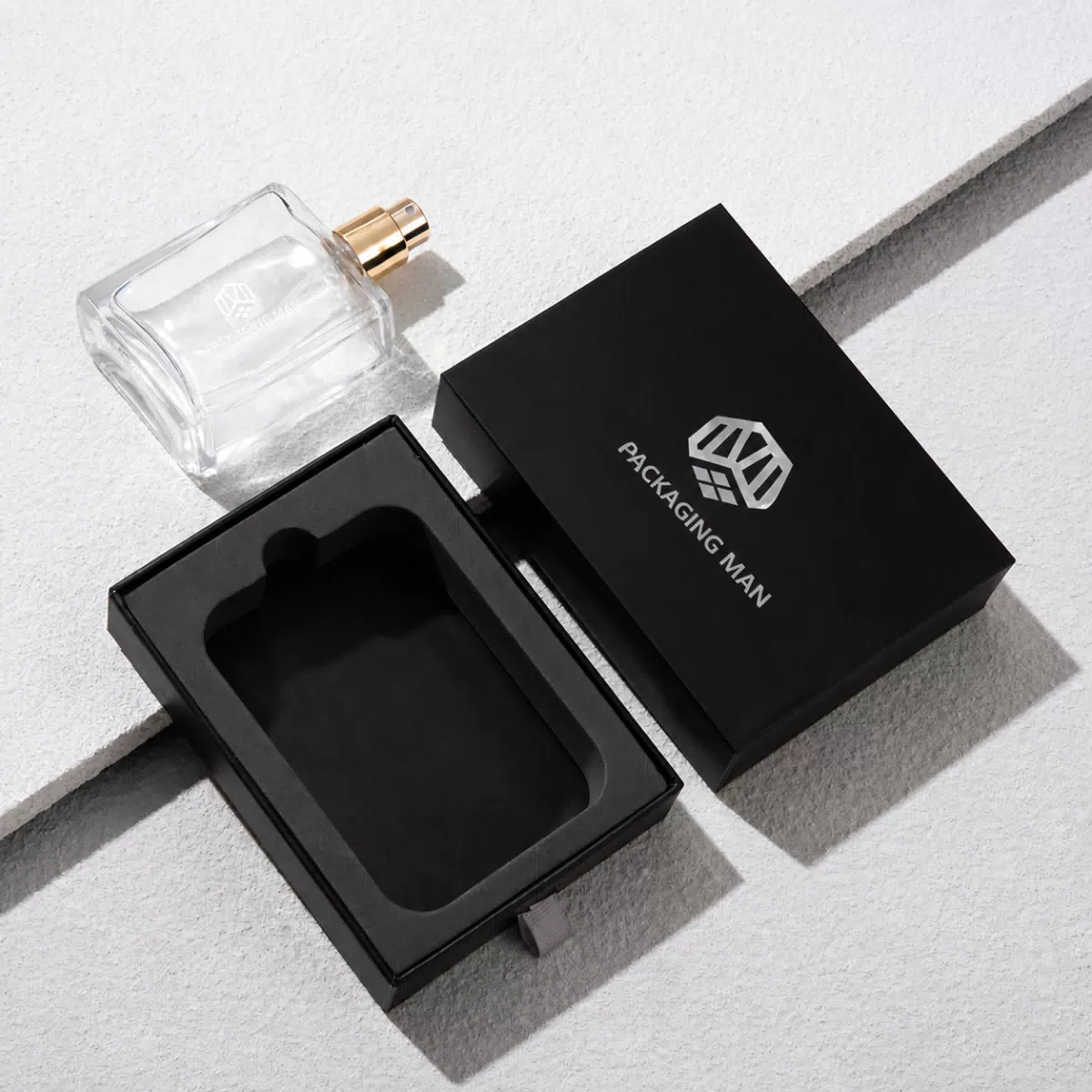 Black packaging box next to glass bottle