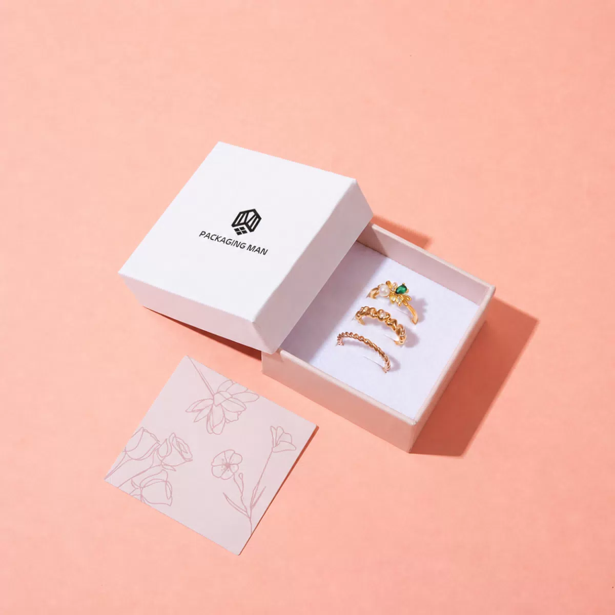 Open white rigid box containing three rings