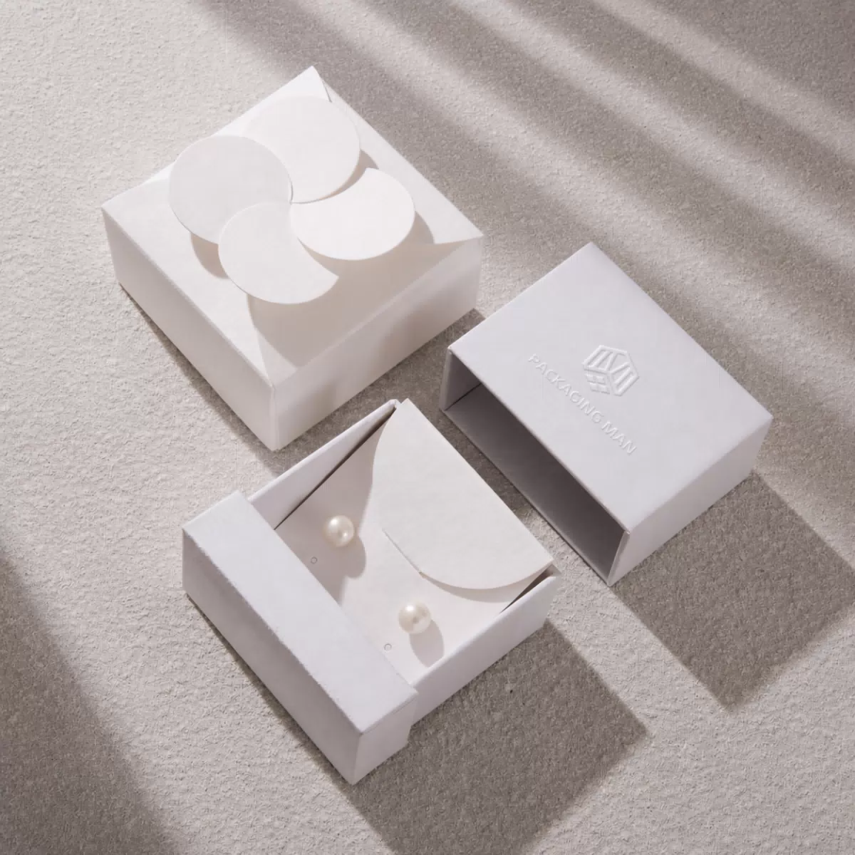 Open white gift box with pearl earring insert