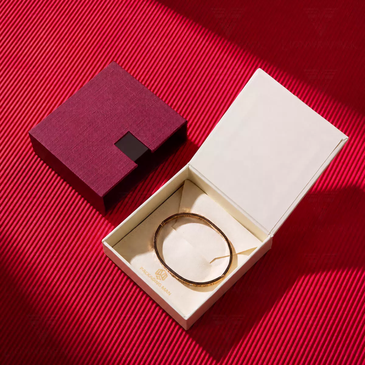 Open burgundy gift box with gold bangle