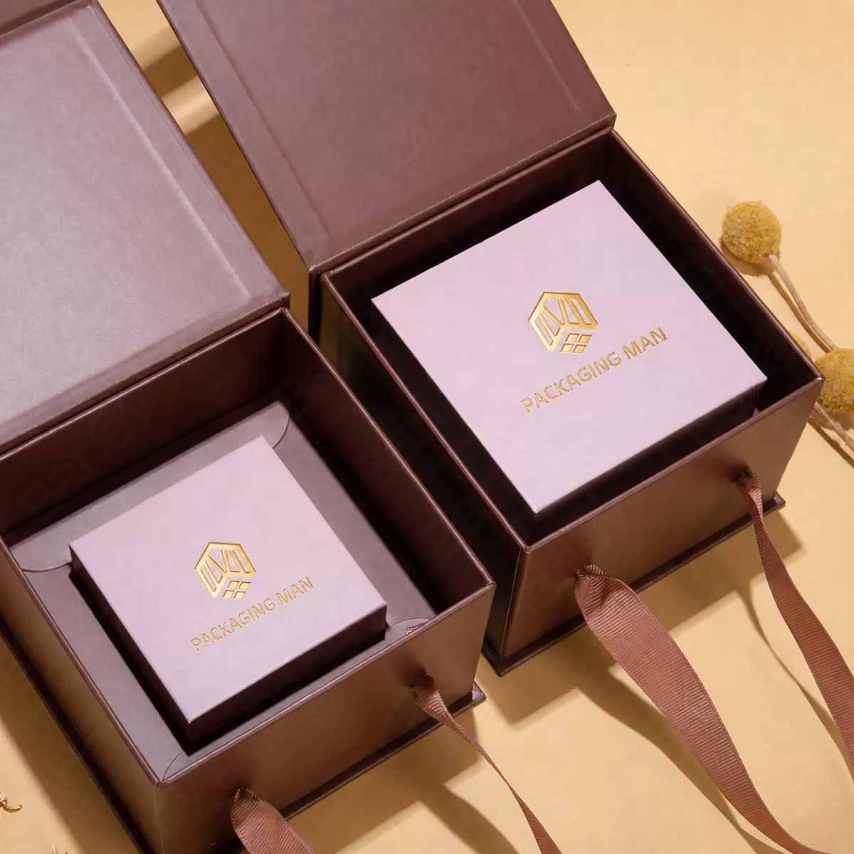 Two open brown boxes containing pink boxes