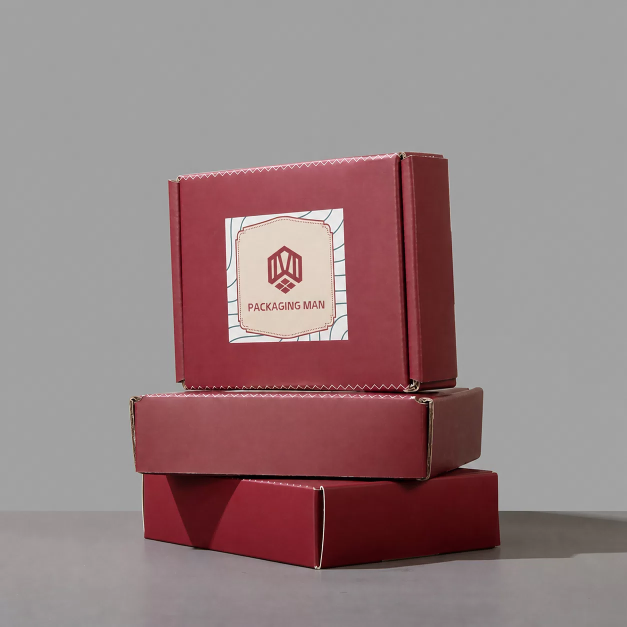 Three red packaging boxes stacked vertically against a neutral background, highlighting the label design on the top box.