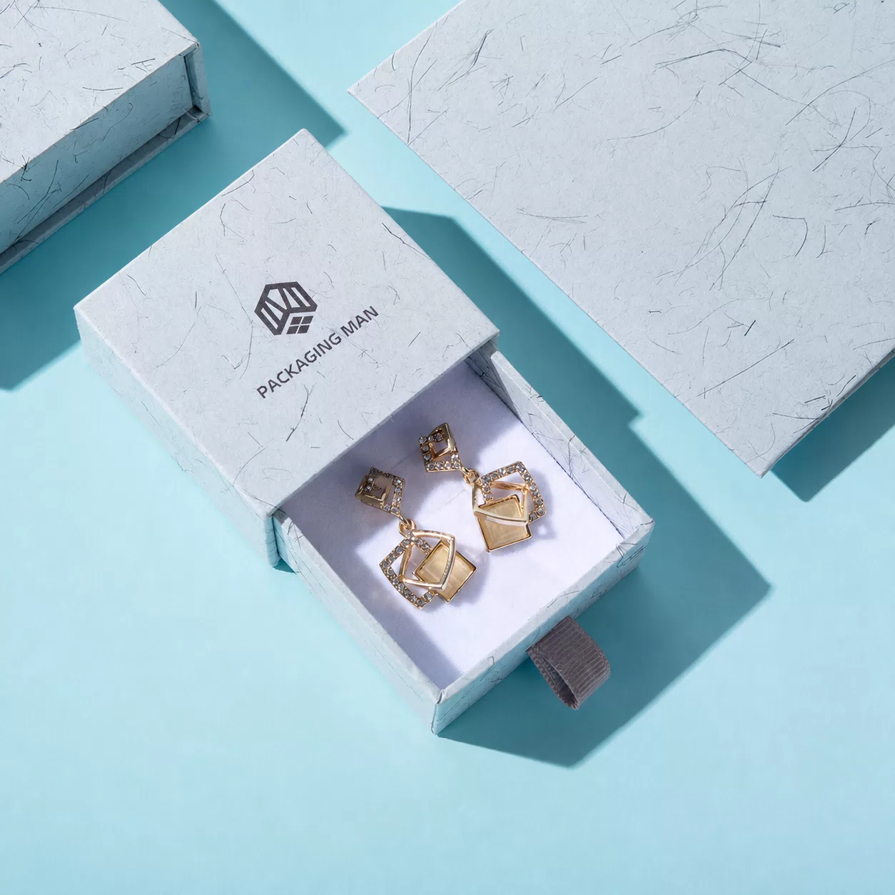 Open marble drawer box with gold earrings