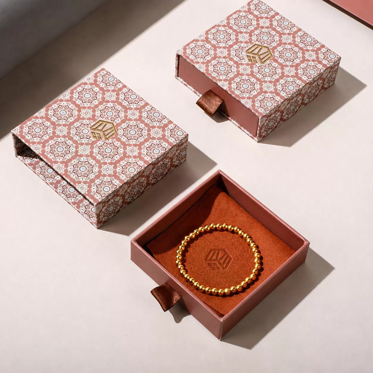 Open pink drawer box with gold bead bracelet