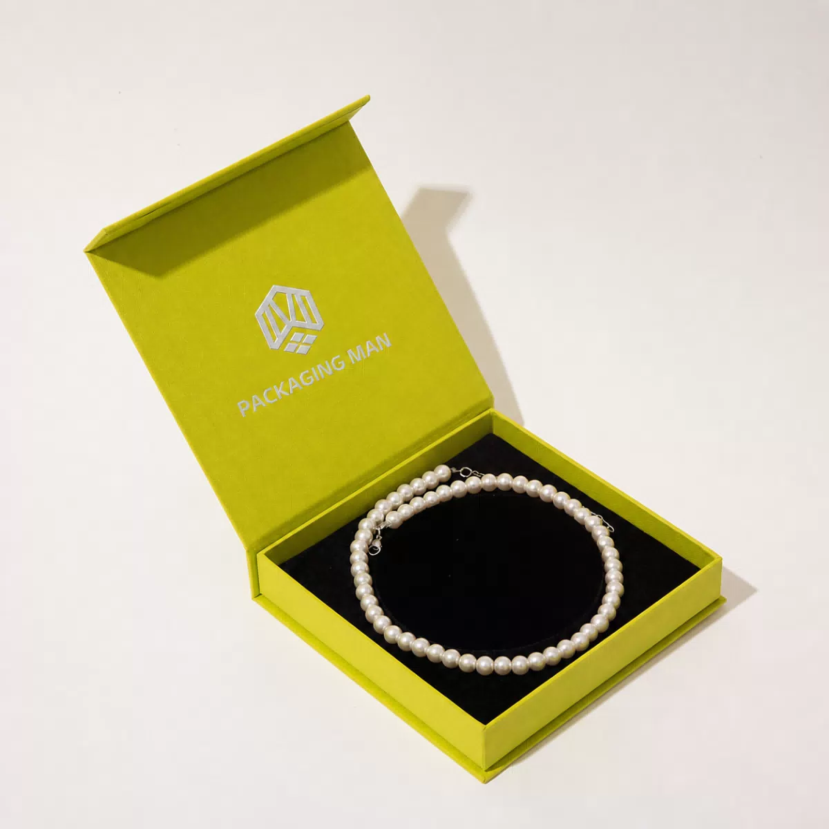 Open green rigid box with black insert
