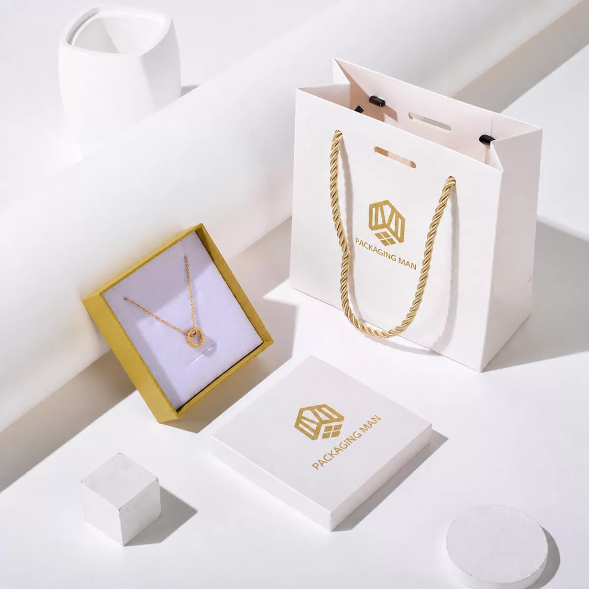 Open white gift box with necklace and paper bag