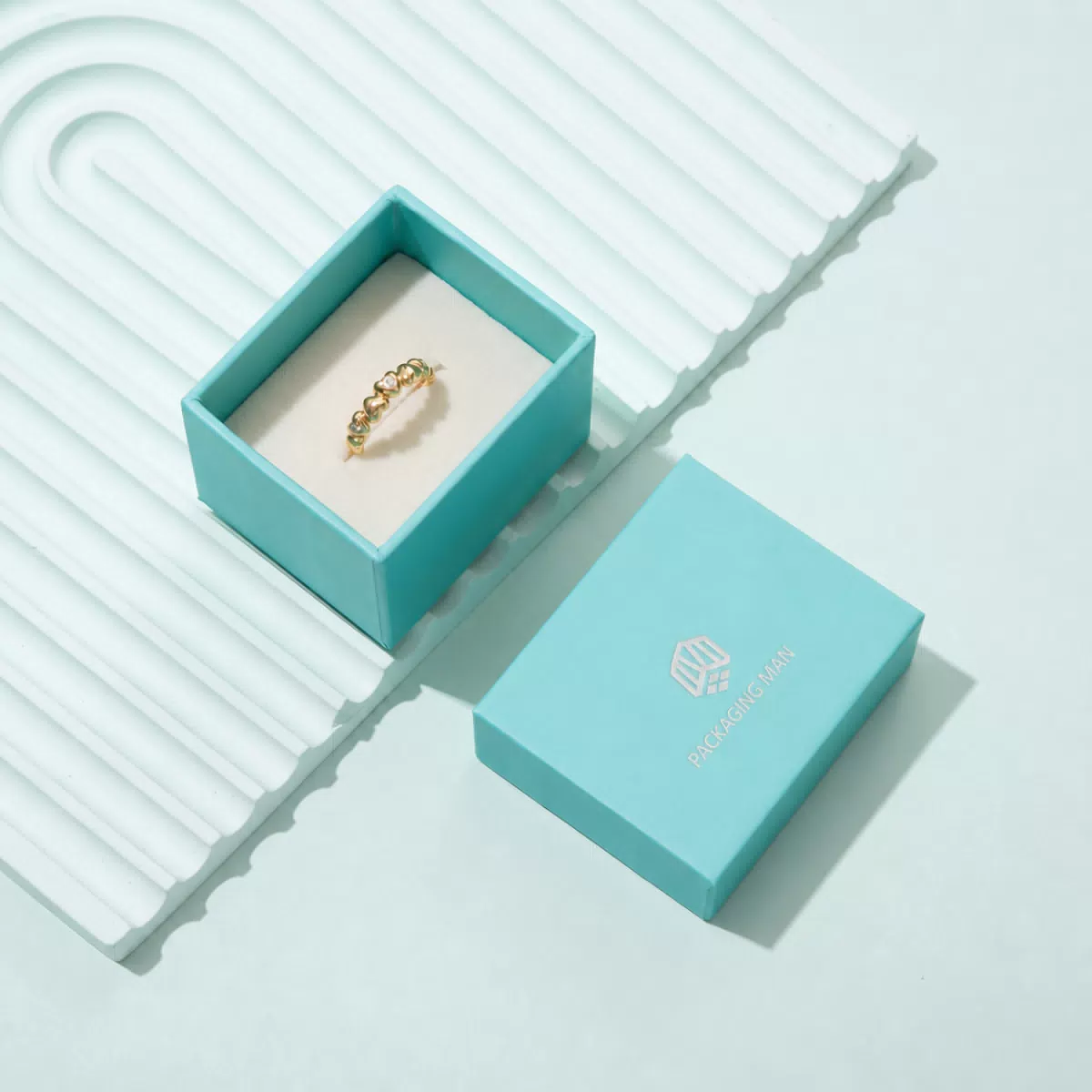 Open turquoise jewelry box with gold ring